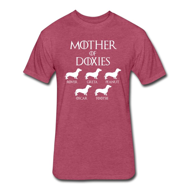 May include: A heather red t-shirt with the text "Mother of Doxies" in white. Below the text are five white silhouettes of Dachshunds with the names "Rover", "Greta", "Peanut", "Oscar", and "Tootsie" underneath each dog.