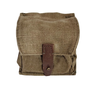 Puede incluir: Una bolsa de lona verde oliva vintage con una correa de cuero marrón y un cierre de metal. La bolsa rectangular tiene un cierre de solapa y una superficie texturizada, lo que sugiere un diseño duradero. La bolsa es probablemente para llevar objetos pequeños.