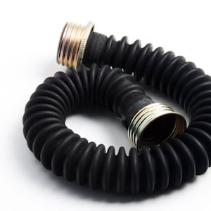 Op de afbeelding: Een zwarte rubberen slang met een gegolfd ontwerp en metalen uiteinden. De slang is opgerold en klaar voor gebruik.