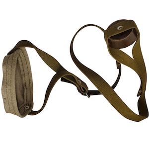 May include: An olive green leather and canvas shoulder strap with a brown leather cup. The strap has a rectangular canvas pad and adjustable buckles. The design is vintage and utilitarian.