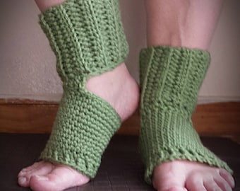 May include: A pair of green crocheted ankle socks with an opening at the heel. The socks are worn on a person's feet.