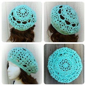 May include: A turquoise crocheted beret with a lacy design. The beret is shown on a mannequin with brown hair and on a flat surface.