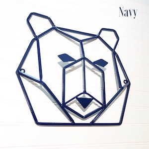 May include: Navy blue geometric metal bear head wall decor. The bear's face is made of a series of connected triangles and squares.