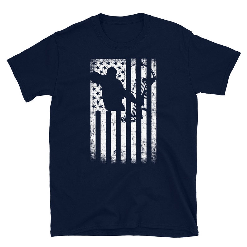 May include: Navy blue t-shirt featuring a distressed white graphic of an archer aiming a bow and arrow, set against a stylized American flag design. The design includes stars and stripes, creating a patriotic theme.