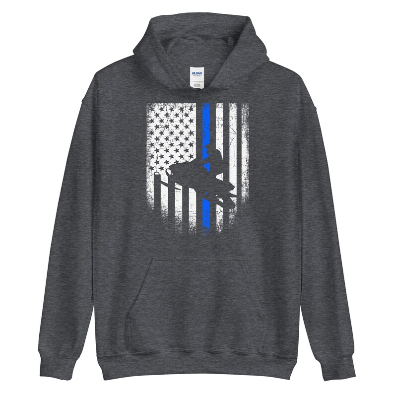 May include: A dark grey hooded sweatshirt with a distressed American flag design featuring a blue line down the center and a silhouette of a person riding a snowmobile.