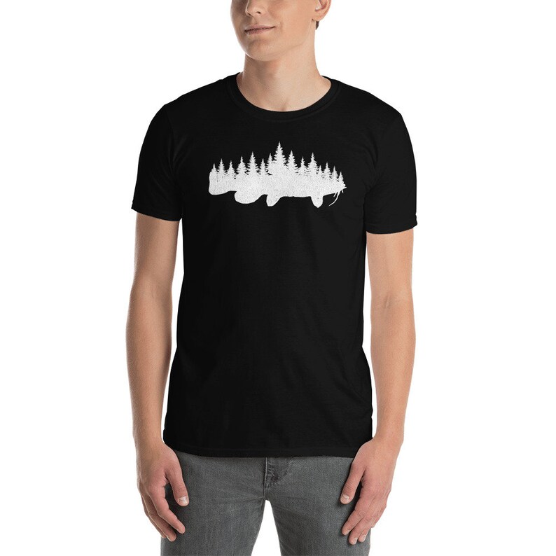 May include: A black t-shirt with a white silhouette of a catfish with a forest of trees growing out of its body.