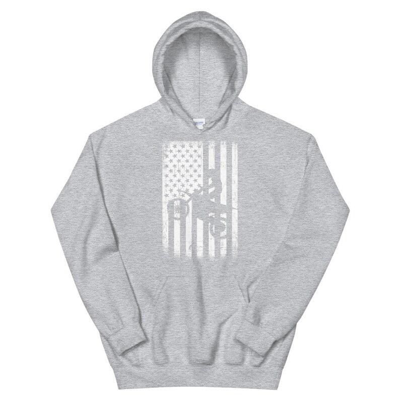 May include: A gray hooded sweatshirt with a white distressed American flag design featuring a silhouette of a person working on a power line.