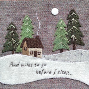 May include: A felt appliqué of a snowy winter scene with a small brown cabin, three evergreen trees, and a white moon. The text "And miles to go before I sleep..." is stitched in black thread on a white felt banner.