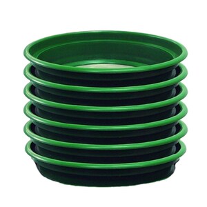 May include: A stack of eight green plastic gold panning dishes. The dishes are stacked on top of each other, with the top dish slightly offset from the others.