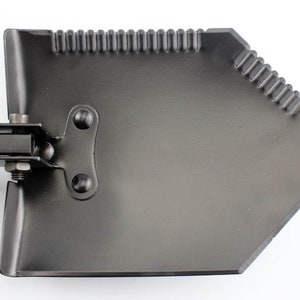 May include: A black folding shovel with a metal handle. The shovel has a serrated edge and a pointed tip.