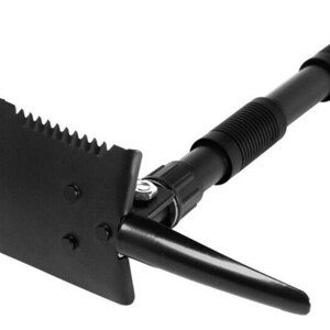 May include: A black folding shovel with a serrated edge and a telescopic handle. The shovel has a pickaxe on the opposite side of the blade.
