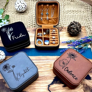 Puede incluir: Tres cajas de joyer&iacute;a personalizadas con diferentes dise&ntilde;os florales y nombres: Frida, Elizabeth y Cadence. Las cajas est&aacute;n hechas de piel sint&eacute;tica y tienen una combinaci&oacute;n de colores marr&oacute;n, gris y negro.