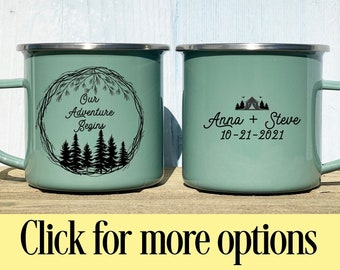 May include: Two green enamel mugs with black text and images. One mug says "Our Adventure Begins" with a wreath of pine branches and trees. The other mug says "Anna + Steve 10-21-2021" with a tent and trees.