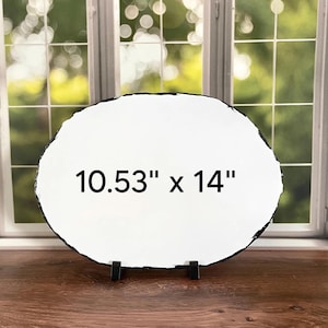 May include: An oval-shaped white slate plaque with a rough, dark, textured edge. The center of the plaque features the black printed text 10.53" x 14". The plaque is supported by two small black stands at the base, displaying its dimensions clearly.
