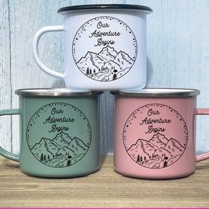 K&ouml;nnte beinhalten: Drei Emailletassen mit schwarzen R&auml;ndern und Griffen. Die Tassen sind wei&szlig;, gr&uuml;n und rosa. Jede Tasse hat ein schwarz-wei&szlig;es Motiv von Bergen und den Text "Our Adventure Begins".