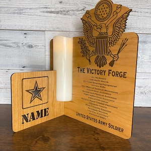 May include: A wooden plaque with a star and the text "NAME" on the left side. The right side features a wooden eagle with the text "THE VICTORY FORGE" and a list of military training activities. The text "UNITED STATES ARMY SOLDIER" is at the bottom.