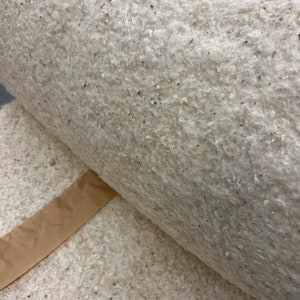 K&ouml;nnte beinhalten: Nahaufnahme einer Rolle handgesch&ouml;pften Papiers mit einer rauen, strukturierten Oberfl&auml;che. Das Papier besteht aus nat&uuml;rlichen Fasern und hat eine hellbraune Farbe.