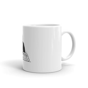 May include: A white coffee mug with a black and white illustration of a person sitting at a desk with a stack of books. The person is wearing a suit and tie. The text on the books reads 'MILL ST.'