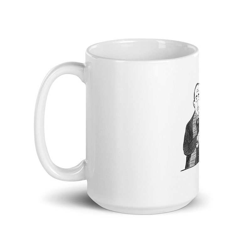 May include: A white ceramic coffee mug with a black and white illustration of a person wearing a suit and tie. The person is smiling and holding a cup of coffee.