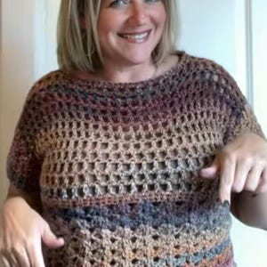 Puede incluir: Top de crochet de manga corta y tejido abierto en tonos marrón, beige, gris y morado. El top se lleva con vaqueros azules. El patrón de crochet crea un diseño texturizado y transpirable.
