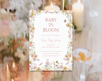 May include: A floral baby shower invitation with a white background and pink text. The invitation reads "Baby in Bloom" and includes the details of the event, including the date, time, and location. The invitation is decorated with a floral border.