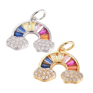 May include: Two rainbow charm pendants with clouds and colorful rainbow accents. The charm on the left is silver and the charm on the right is gold.