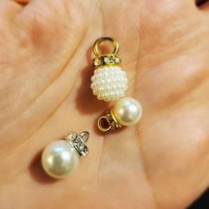 May include: Two pearl and rhinestone embellishments with gold and silver accents. The embellishments are perfect for adding a touch of elegance to crafts and jewelry.