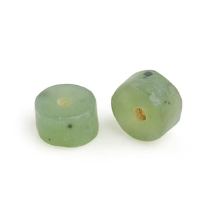 May include: Two green jade beads with a hole in the center. The beads are round and have a smooth surface.