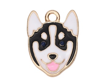 Könnte beinhalten: Goldfarbener Metall-Anhänger mit einem schwarz-weißen Husky-Hund mit blauen Augen und einer rosa Zunge. Der Anhänger hat oben eine Schlaufe zum Anbringen an einer Halskette oder einem Armband.