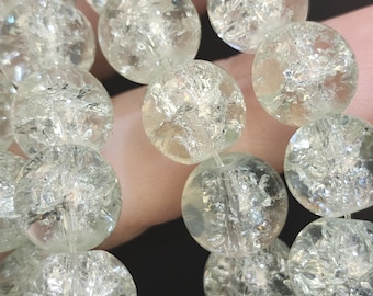 Può includere: Una collana di perline di vetro trasparente con una finitura screpolata e iridescente. Le perline sono rotonde e hanno una forma leggermente irregolare.