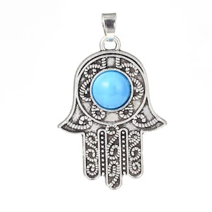 May include: Silver pendant in the shape of a hamsa hand with a blue turquoise stone in the center.
