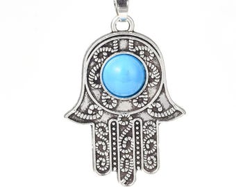 May include: Silver pendant in the shape of a hamsa hand with a blue turquoise stone in the center.