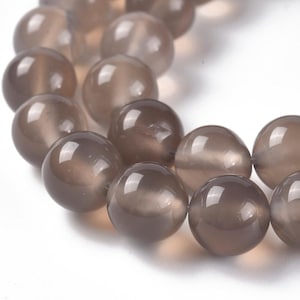 May include: A strand of round, gray agate beads. The beads are smooth and have a slight sheen.
