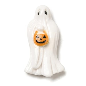 May include: A white ceramic ghost figurine holding an orange jack-o'-lantern bucket. The ghost has black eyes and a smiling face on the pumpkin. A Halloween decoration.