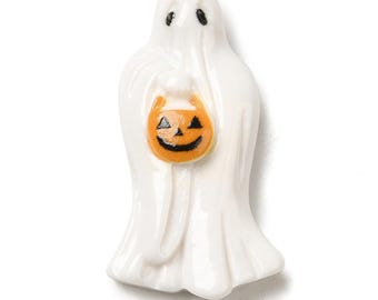 May include: A white ceramic ghost figurine holding an orange jack-o'-lantern bucket. The ghost has black eyes and a smiling face on the pumpkin. The figurine is a Halloween decoration.