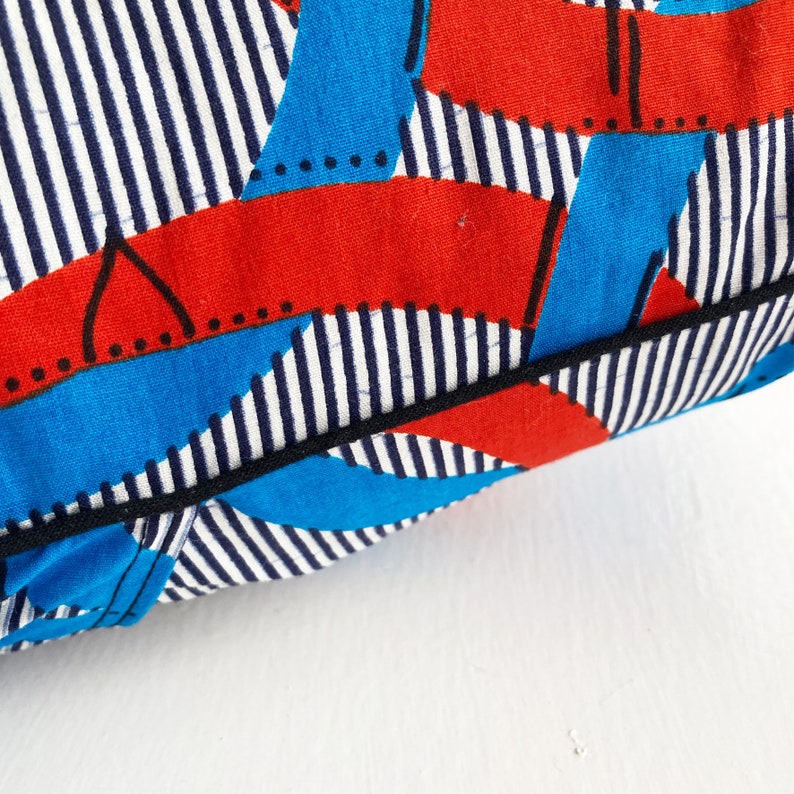 Brightly coloured African print cushion in blue decorative white and red
