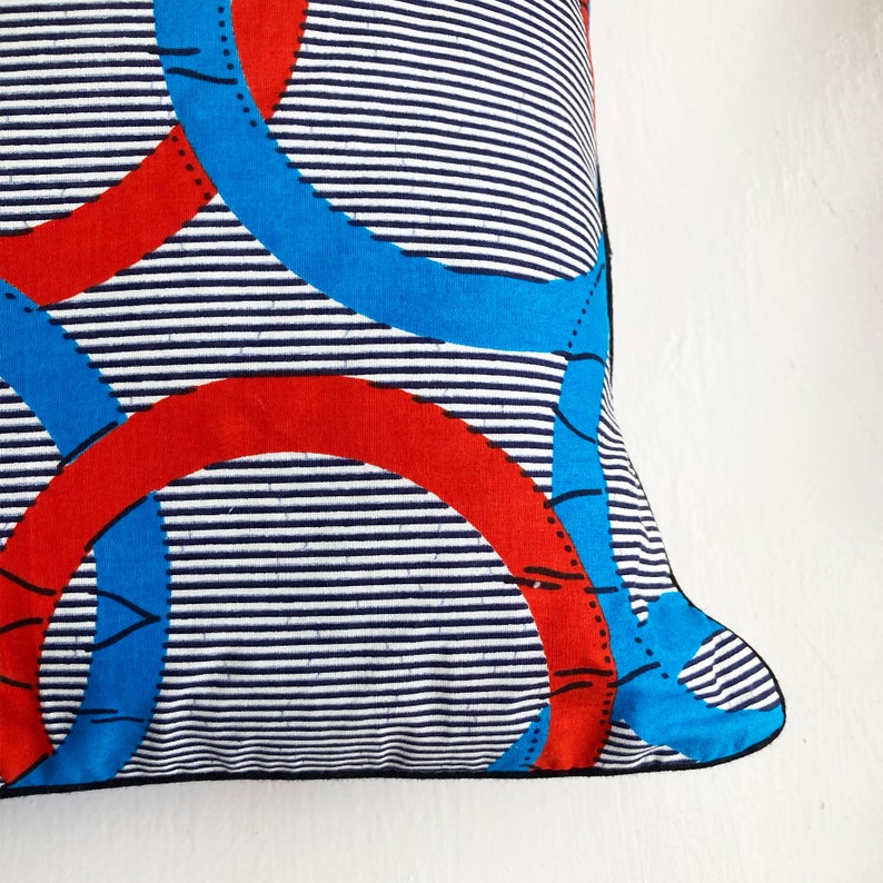 Brightly coloured African print cushion in blue decorative white and red