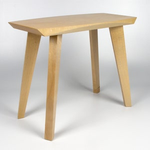 May include: A light wood side table with a rectangular top and four legs. The table has a simple, modern design.