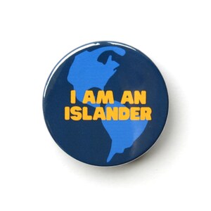May include: A blue and navy blue button with a stylized image of the Earth and the text "I AM AN ISLANDER" in yellow.