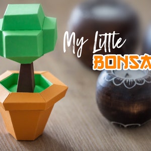 May include: A green paper origami bonsai tree in an orange paper pot. The text "My Little Bonsai" is in the background.