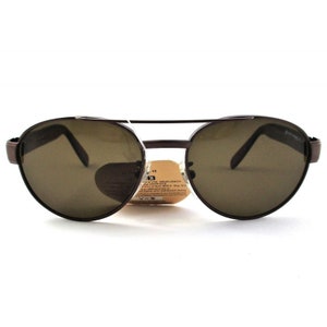 May include: Brown metal aviator sunglasses with brown lenses. The sunglasses have a double bridge and a metal frame.
