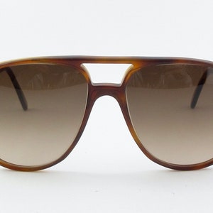 May include: Tortoiseshell aviator sunglasses with brown gradient lenses.