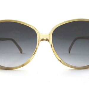 May include: A pair of round, tortoise-shell framed sunglasses with dark gray lenses.