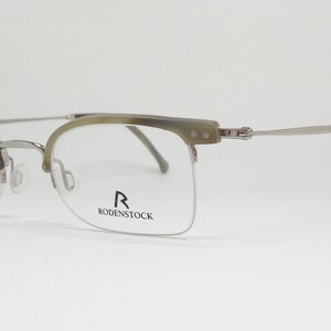 May include: Silver and tortoise shell half-rim eyeglasses with the Rodenstock logo on the right lens.