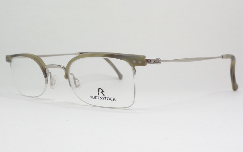 May include: Silver and tortoise shell half-rim eyeglasses with the Rodenstock logo on the right lens.