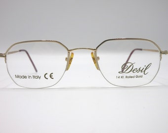 May include: Gold-tone metal eyeglasses with a rectangular frame. The glasses have a clear lens and the words "Desil 14 Kt. Rolled Gold" are printed on the right lens. The words "Made in Italy CE" are printed on the left lens.