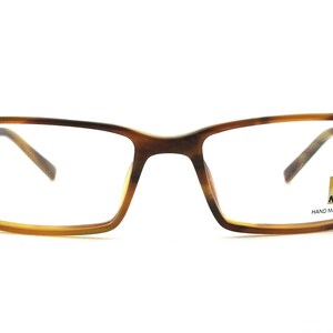 May include: Brown tortoise shell rectangular eyeglasses with clear lenses. The frame has a silver accent on the temples. The right lens has a small gold label that reads "Nikon Hand Made Acetate".