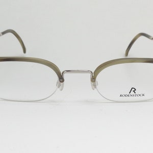 May include: Silver and tortoise shell eyeglasses with clear lenses. The brand name "R RODENSTOCK" is printed on the right lens.