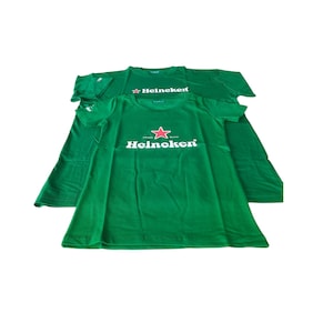 May include: Two green t-shirts with the Heineken logo printed on the front. The logo features a red star and the brand name in white. The shirts are short-sleeved and made of a soft material.