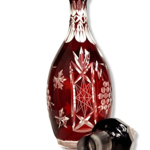 Ruby red Bohemian carafe with cut pattern, crystal glass, table decoration, serving drinks